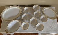Full set of vintage Meito hand painted china pieces displayed on a table, showing 2 large serving plates, 1 serving bowl, and 8 soup bowls arranged neatly.
