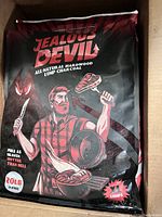 Full front view of unopened 20 lb bag of Jealous Devil hardwood lump charcoal inside a cardboard box.