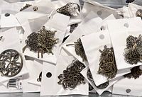 Pile of sealed packages with antique brass tree pendants showing tree of life design