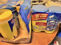 Seven unopened Lysol disinfecting wipes containers, six in a yellow multi-pack and one 2-pack with bonus wipes label