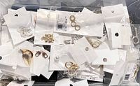 Top view of assorted jewelry findings in plastic packaging showing jump rings and clasps.
