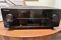 Front view of the Pioneer stereo receiver showing volume knob, USB port, headphone jack, and function buttons.