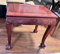 View of the rosewood side table showing claw feet and carved apron detail.