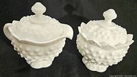 Front angle photo showing arrangement of creamer and sugar bowl with ribbed pedestal bases and hobnail texture