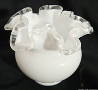 Front view of Fenton Silvercrest ball vase showing white milk glass body and clear crimped top edge.