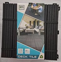 Top view of 10 black deck tiles bundled with packaging showing brand and tile dimensions 12x12 inches.