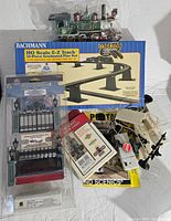 HO scale train locomotive and Bachmann E-Z track set with assorted accessories packed around it