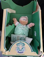 Vintage Cabbage Patch Kids Preemie doll in original green display box showing doll and box condition