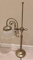 Full view of the vintage brass desk lamp with adjustable arm and frosted glass shade.
