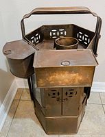 Side and front view showing the overall shape and compartments of the brass noodle cart.