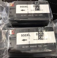 Two 950XL black ink cartridges in original vacuum-sealed packaging stacked on each other, visible caution labels and pull tabs.