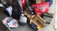 Various cooler bags arranged on floor showing brand logos and colors