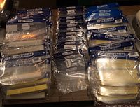 Face shields grouped and laid out on a flat surface showing several multi-packs and individual face shields in packaging