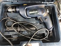 Blue Mastercraft hammer drill in black case, shows drill with attached cord and extra handle.