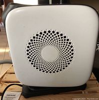 Front view showing white face with circular vent pattern of the heater.