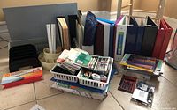Wide view of the lot showing binders, organizing trays with various supplies and piles of paper products