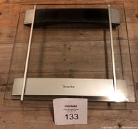 Photo showing the Terraillon digital bathroom scale with glass platform and steel accents.