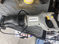 Side view of Workforce electric cut saw showing handle, trigger, blade guard, and power cord.