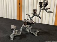 Overall view of the cast metal candle holder shaped like a branch with three birds perched and three candle holders attached.
