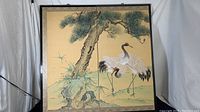 Front view of the two-panel screen laid flat showing painted crane and pine tree artwork