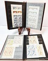 Two open books with black album pages showing multiple blocks of collector stamps from late 1970s