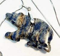 Close up of the sodalite stone bear pendant highlighting the hand carved details and natural color patterns.