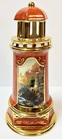 Full view of porcelain lighthouse night light, showing overall shape and finish with gold accents and artwork