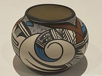 Front and side view of the vintage Hopi pottery bowl showing detailed painted geometric and bird motifs with colors black, brown, blue, white, and grey.