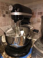 Front view of mixer installed with bowl, whisk and pouring shield
