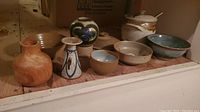Overview of six pottery items including two bowls, three vases, and one wooden vase.