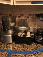 KitchenAid blender and Cuisinart food processor with attachments on countertop