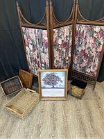Full view of antique screen, baskets, framed wall art, and decorative metal bin arranged on floor