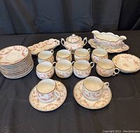 Full set of assorted Bridal Rose China items arranged on a black cloth, showing teacups, saucers, sugar bowl, gravy dish with platter, and relish dish