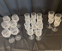 Top view of all three sets of wine glasses grouped: six wide bowl glasses with diamond cuts, six rounded diamond cut glasses, six assorted taller and shorter crystal glasses