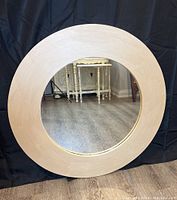 Full view of the round mirror showing the champagne gold painted wood frame and reflective glass.