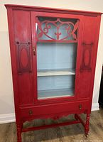 Front view of red exterior and grey interior china cabinet with glass door closed