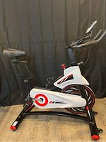 Side profile of full spin bike showing frame, flywheel and pedals