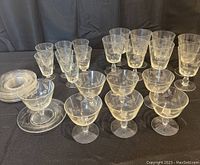 Full set of clear vintage etched crystal glasses with leaf/wheat pattern showing variety of glass types including sherbet/sorbet glasses, footed goblets, smaller goblets and stacked saucers.