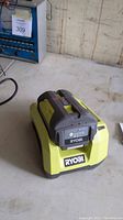 Ryobi 40V lithium battery placed on the matching charger showing the product and branding clearly.