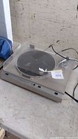 Front angle of Sansui FR-D3 turntable with dust cover closed. Shows overall condition including scratches.