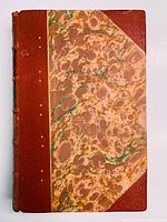 Front cover showing half leather marbled binding with green, brown, and yellow splotches in the paper and reddish-brown leather.