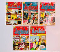 Five vintage Archie and Jughead comic books displayed flat showing front covers with bright colorful images and titles including an edition in French.
