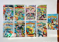 Overview of ten Super Friends comic books spread out on a white surface showing colorful front covers with characters such as Batman and the Wonder Twins.
