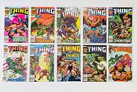 12 Marvel Comics The Thing comic books laid out in two rows showing their covers front-facing. Covers feature various colorful artwork of The Thing character and other figures in dynamic comic book scenarios.