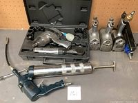 Set of air tools including grease gun, impact wrench with sockets, air ratchet, and air tool heads.