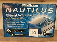 Box of Motomaster Nautilus Intelligent Battery Charger showing front with features and rapid/trickle charge info.