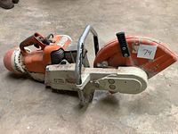 Side view of concrete cut-off saw showing blade guard and handles