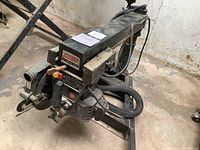 Front and side view of Craftsman 10-inch radial arm saw showing the saw blade, control switches, and dust hose attachment.