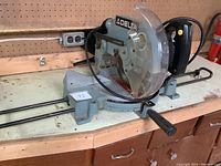 Photo showing side view of Delta 10 inch mitre saw on workbench with power cord coiled around base.