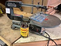 Front view of Delta scroll saw on workbench with Lepage can of chisels in foreground